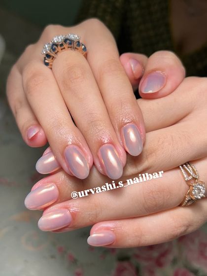 This set features a beautiful pearlescent chrome finish over a soft nude base. The iridescent shine gives the nails a Hailey Bieber-esque glazed donut look that is both trendy and timeless.