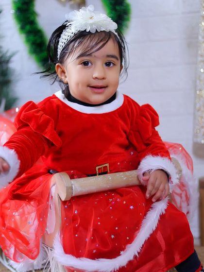 A sweet portrait of a little girl in her Santa dress, ready for her Christmas-themed photoshoot.