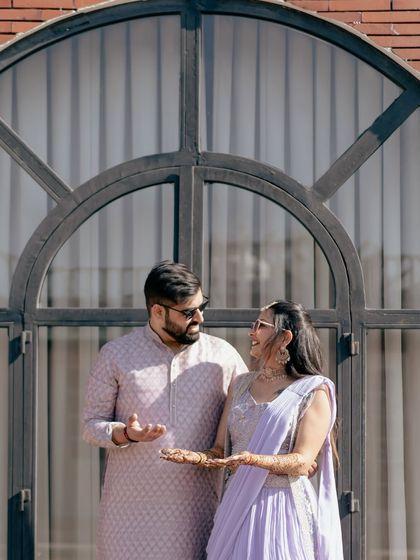 A fun, candid interaction during a sunlit pre-wedding shoot. Their laughter and playful gestures show their genuine connection.