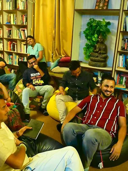 This is what community looks like. A cozy corner filled with people sharing stories and poems during our Rhyme and Rhythm collective, surrounded by books and soft light.