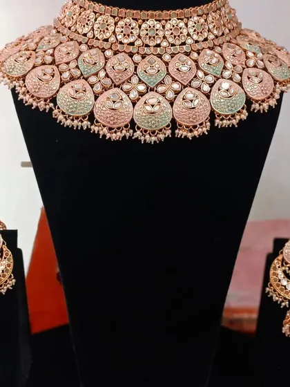 A close-up of a beautiful meenakari choker set in pastel pink and mint green. This is a very popular rental choice for Mehendi functions.