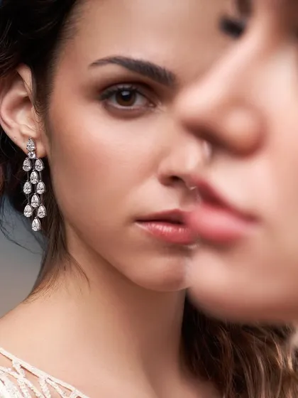 A creative portrait for Solitario Diamonds, using a reflection to create a sense of duality. The focus remains on the stunning diamond drop earrings.