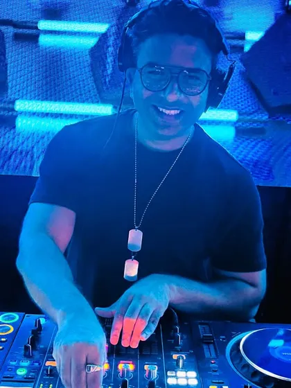 In my element, behind the decks. My job is to read the room and play the tracks that keep everyone moving. This shot captures me during a live set, focused on the music and the dance floor.