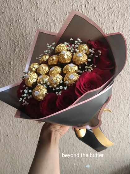 A classic romantic gift: a beautiful bouquet of fresh red roses and Ferrero Rocher chocolates, all hand-tied and wrapped.
