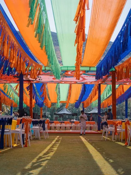 Colorful fabric drapes create a festive ceiling for this outdoor Mehendi ceremony, adding to the lively atmosphere.