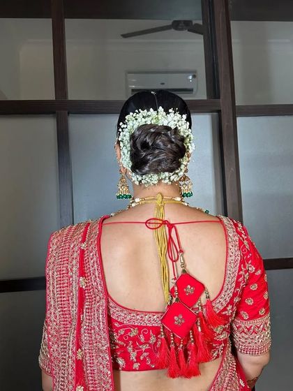 A classic bridal bun with a simple, elegant gajra. This look is perfect for a traditional bride who wants a timeless and sophisticated hairstyle.
