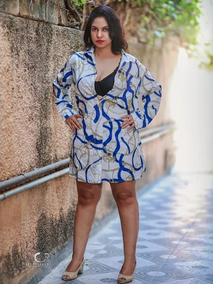 Taking the studio look outdoors. The rough texture of the wall contrasts with her stylish outfit, creating an edgy, urban-chic fashion portrait.