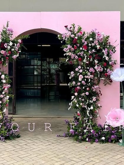 The grand entrance we designed for Arha's tonsure ceremony. A large pink archway adorned with fresh flowers and a personalized welcome sign created a memorable first impression for guests.