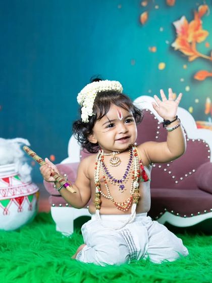 This little Krishna is waving happily, surrounded by pots of butter.