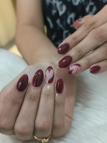 A close-up shot that captures the glossy finish and the clean lines of the heart-shaped accent nail art.