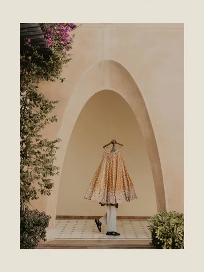 An artistic shot of the bride's lehenga hanging in a beautiful archway. This turns a simple detail shot into a piece of art.