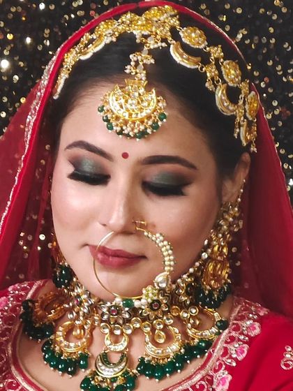 A beautiful bridal set with a unique crescent design and green bead drops. The matching matha patti and oversized earrings complete the look.