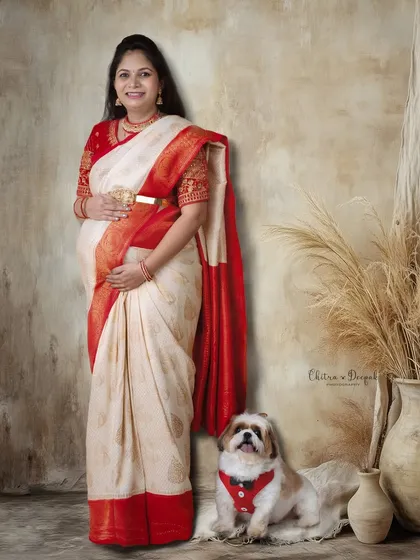 A beautiful portrait of an expecting mother in a traditional saree, posing with her cute dog in our studio.