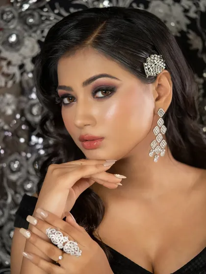 This close-up shows the detail of the smokey eye makeup and the sparkling hair accessory. It's a look that is sure to turn heads at any party.