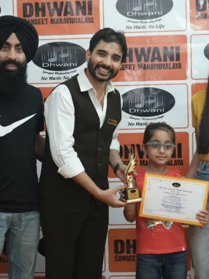 A family poses with a teacher to celebrate their daughter's art award.