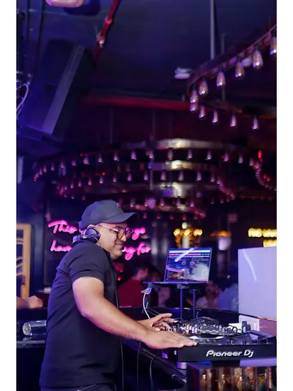 Focused on the mix, making sure every transition is seamless. Here I am at the Pioneer DJ console, crafting the sound for the night.