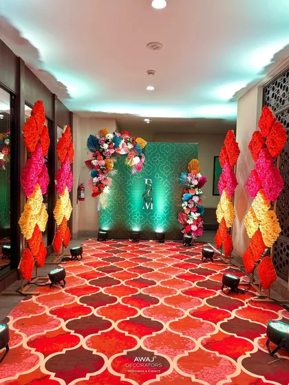 The end of the walkway, leading to a photo backdrop with the couple's monogram and a lush floral arch.