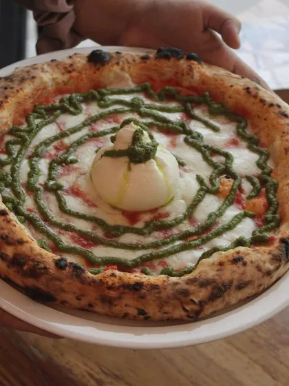 Holding up our Burrata Pesto pizza. It's a work of art that tastes as good as it looks.