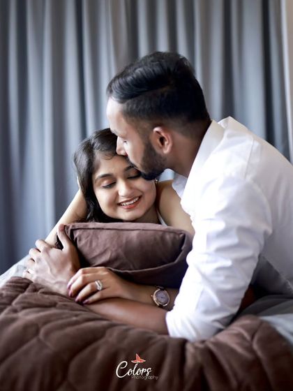 A tender forehead kiss in a cozy bedroom setting, highlighting warmth and intimacy.