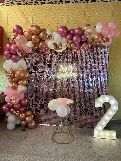 A glamorous rose gold and pink shimmer wall decoration for a 2nd birthday, showing that stylish themes can be for all ages.