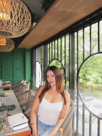 A smiling shot in the white top and jeans, perfect for a sunny day at a cafe.