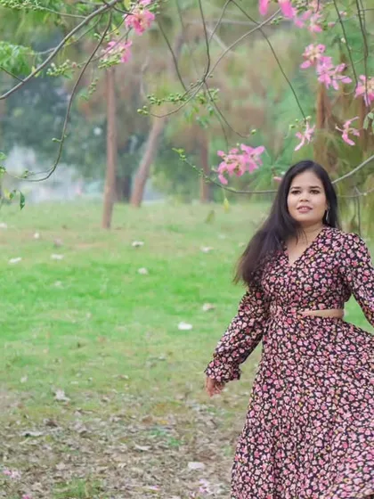 A wide shot of the bride-to-be, capturing the flow of her dress and the beauty of the park setting during her pre-wedding candid photoshoot.