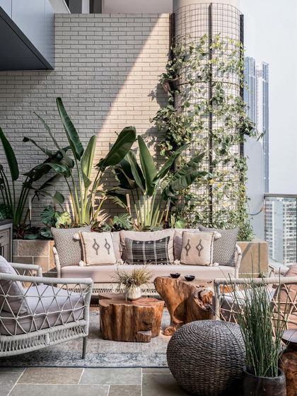 The heart of this home, the deck, features a warm vanilla limestone floor in a river-washed finish. A 3-seater outdoor sofa and two chairs provide ample space for lounging amidst inviting planters.