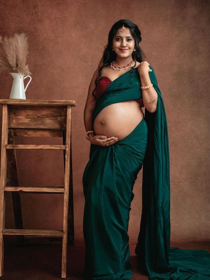 This mom-to-be is embracing the grace of a traditional saree shoot. The simple props and warm background create a beautiful fine art portrait.