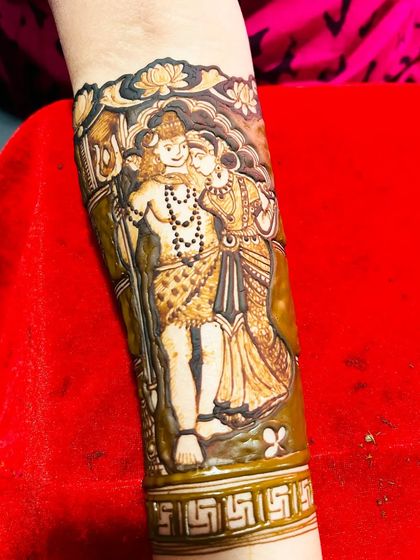A close-up of a divine Shiv-Parvati portrait on the forearm. The shading and detail work bring the figures to life, creating a piece of art that is both beautiful and meaningful.
