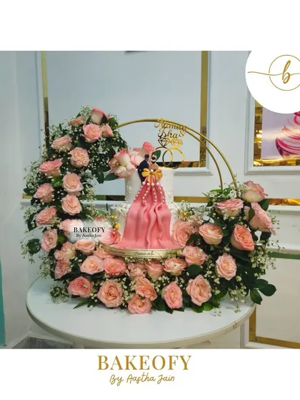 For Naman and Isha's engagement, I designed this elegant 2.5 kg Lotus Biscoff cake. The centerpiece is a beautiful draped fondant design, surrounded by a ring of fresh pink roses. It’s a perfect blend of sophisticated design and delicious flavor.