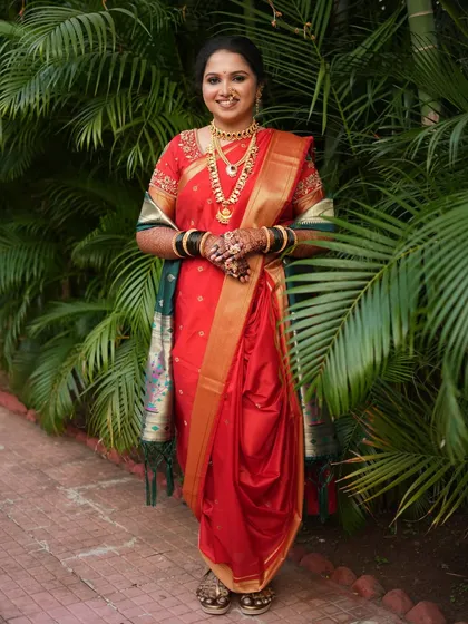 This bride looks stunning in her red Nauvari saree. The airbrush makeup ensures a flawless finish that lasts through all the wedding rituals.