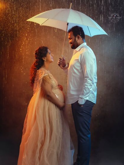 A romantic couple's portrait under an umbrella, with a warm and cool lighting setup creating a cinematic rain scene.