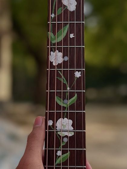 A close-up shot of the painted flowers on the guitar fretboard. I used durable paint to make sure the design lasts.