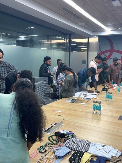 A corporate training session is highly interactive. Here, participants are engaging in a hands-on activity to understand how accessories and clothing details can effectively manage one's image in professional and social scenarios.