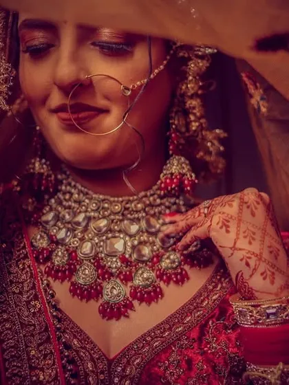 A dramatic bridal portrait using a red veil and low-key lighting to create a sense of intimacy and highlight the bride's features.