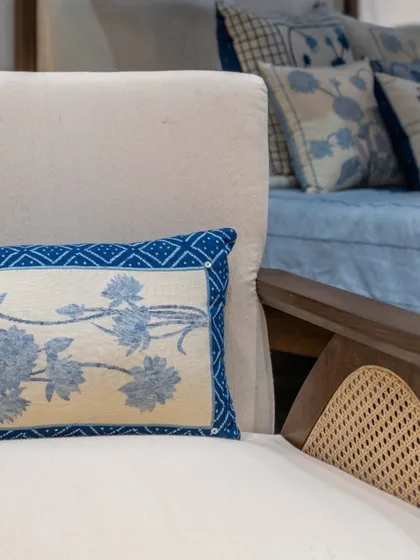 A detail shot showing the fine craftsmanship of our seating. The combination of a solid wood frame, natural cane, and handwoven khadi fabric with delicate embroidery highlights our commitment to texture, detail, and artisanal quality.