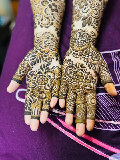 A close-up of the palms for a "Baat Pakki" ceremony. The floral patterns are dense and intricate, perfect for a celebration.