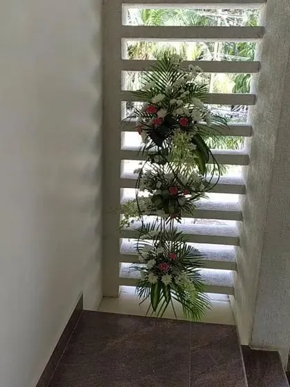 This image shows how we can use vertical spaces for decoration. These floral arrangements are designed to fit within narrow nooks, adding beauty without taking up floor space in a home setting.