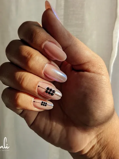 A minimalist design on nail extensions featuring simple black lines and crystal clusters.