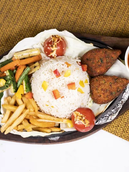 A sizzling symphony of flavors. This sizzler includes mouthwatering BBQ cutlets, tender baby corn, roasted carrots, fries, and rice.