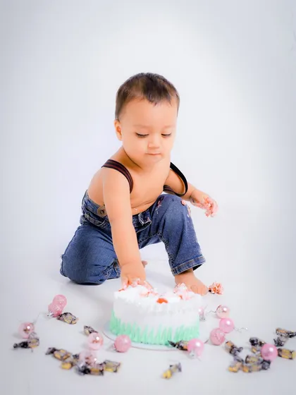 A candid shot of the baby curiously exploring his first birthday cake. These initial moments are always so sweet and gentle.