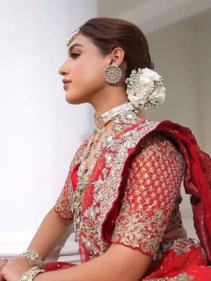 A close-up of the side profile, highlighting the intricate earrings and the delicate floral arrangement in the hair. Every detail is curated for a cohesive bridal look.