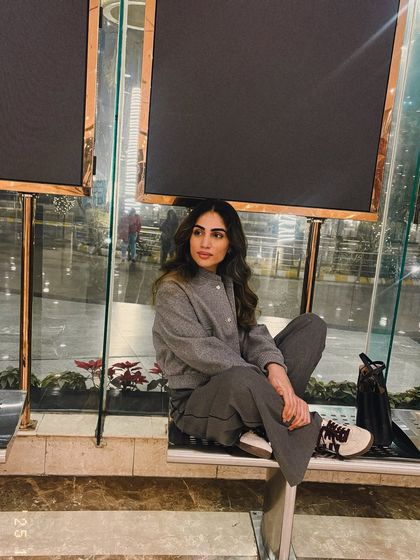 A relaxed, seated pose in my grey winter co-ord look. Comfort is key, especially during colder months.