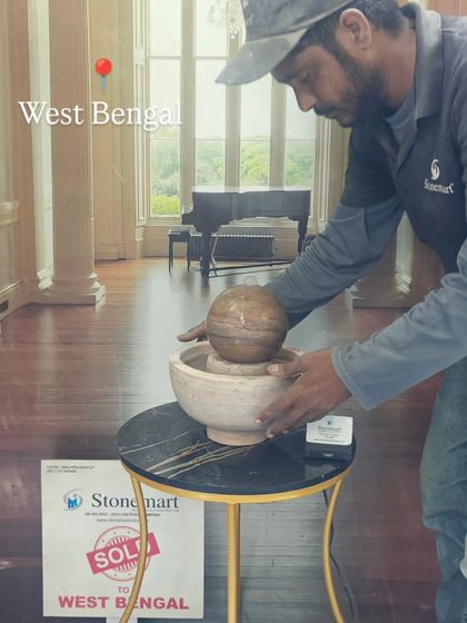 An artisan makes a final check on the small tabletop fountain before it is packed.