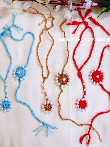 These handmade crochet Rakhi and Lumba sets are available in a variety of colors like sky blue, golden brown, and bright red, each adorned with delicate pearls.