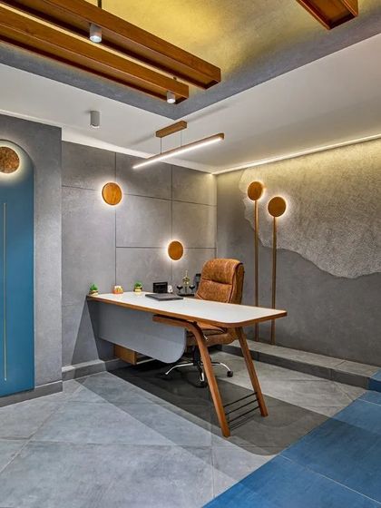 The doctor's consultation room uses a sophisticated palette of grey concrete textures, wood, and custom lighting to create a calm and authoritative space.