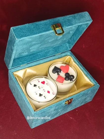 The open velvet box showcasing the two distinct poker-themed candle designs.
