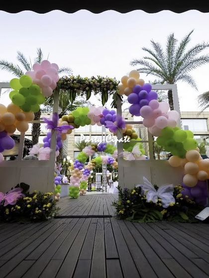 Another view of the grand entrance, showing how the balloon arch and butterfly props frame the walkway, inviting guests into the magical celebration.