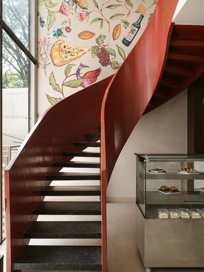 This sculptural red staircase was designed to be a central feature, connecting floors while adding a dramatic curve of elegance. Paired with a custom mural, it transforms a functional element into a piece of art.