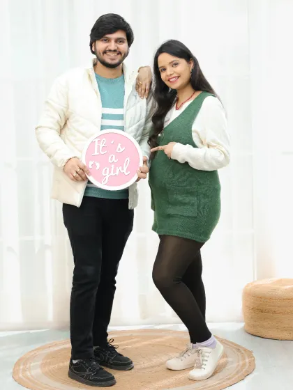 Announcing the gender with a cute sign is a popular and fun addition to any maternity shoot. This couple is all smiles as they share that it's a girl.